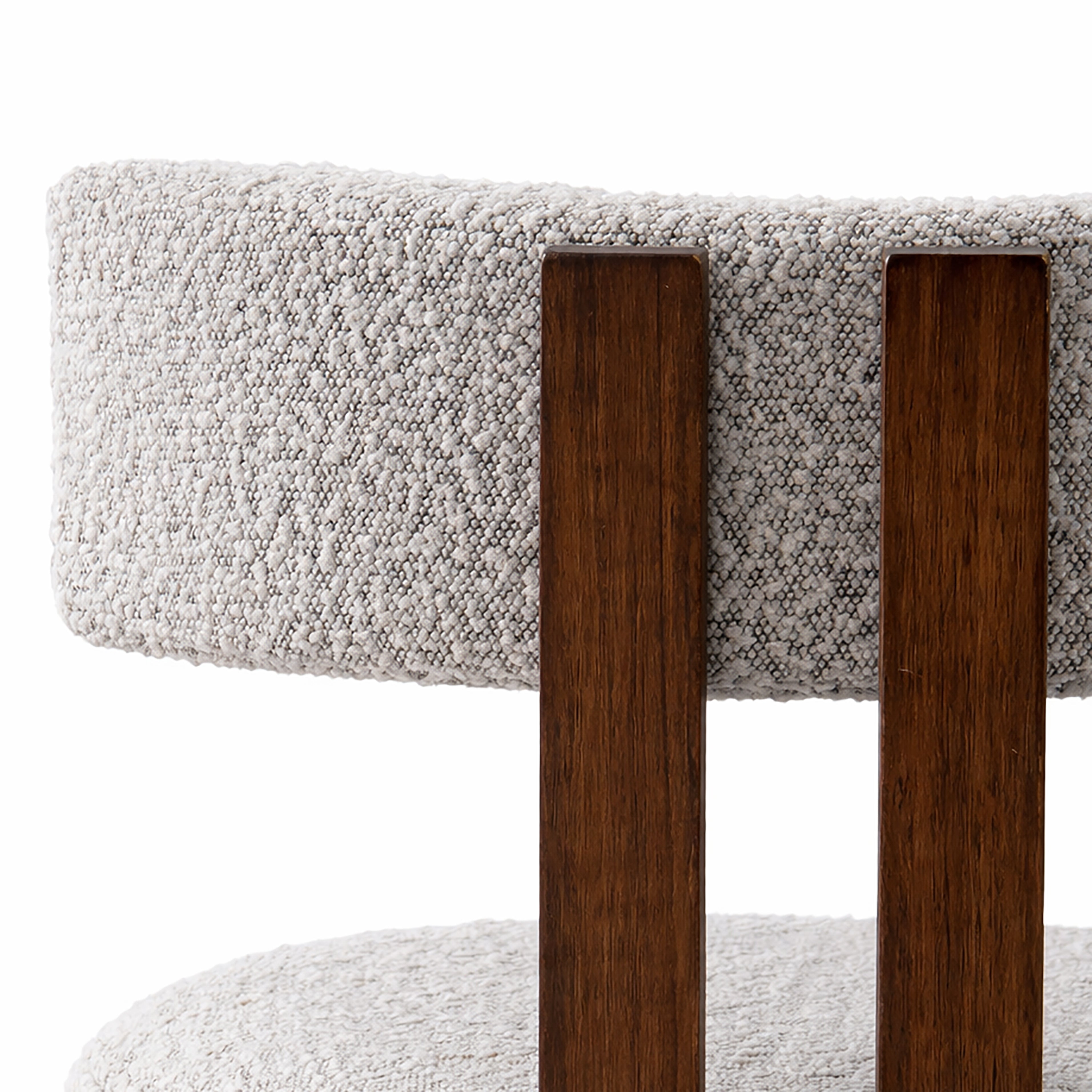 Close-up of a chair with wooden legs and textured gray boucle cushioned seat and backrest.